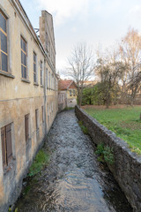 Fototapeta na wymiar Small river between buildings in Kuldiga city, Latvia.