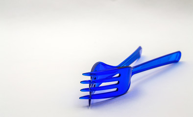 blue plastic fork on white background close-up