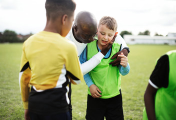 Naklejka premium Football coach with his students