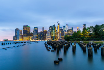 Obraz premium Manhattan panoramic skyline at night from Brooklyn Bridge Park. New York City, USA. Office buildings and skyscrapers at Lower Manhattan (Downtown Manhattan)..