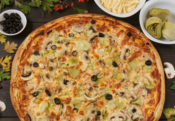 Pizza with black olives, artichokes and ham.