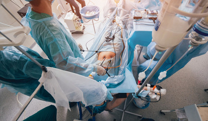 Process of gynecological surgery operation using laparoscopic equipment. Group of surgeons in...