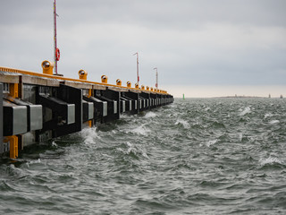 Waves lapping against pier on a windy day