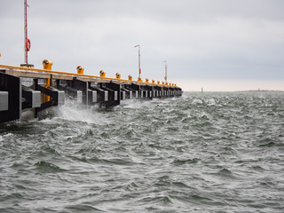 Waves lapping against pier on a windy day