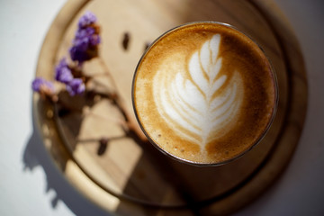 cup of coffee with cream on wooden background