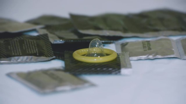 Ready to use condoms among the sealed packages with condoms, close-up