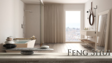 Wooden vintage table shelf with stone balance and 3d letters making the word feng shui over blurred classic luxury bathroom with bathtub, zen concept interior design