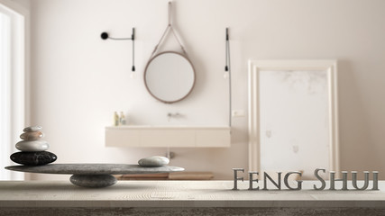 Wooden vintage table shelf with stone balance and 3d letters making the word feng shui over blurred...