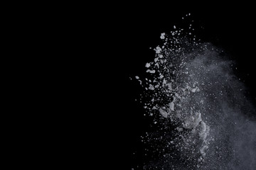 White powder explosion on black background. Dust splatted isolated. Paint Holi.