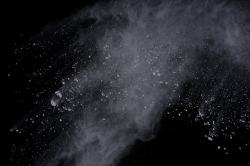 White powder explosion on black background. Dust splatted isolated. Paint Holi.