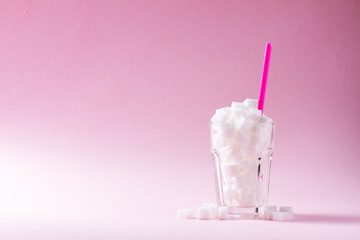 Sugar in glass on on pink background with copy space