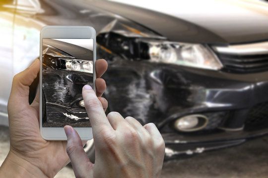 Hand holding smart phone take a photo at The scene of a car crash