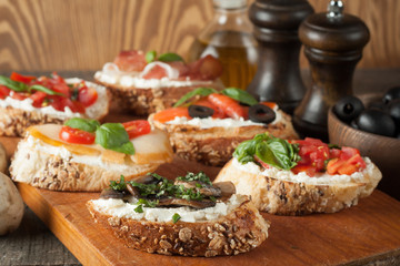 Italian tomato and cheese bruschetta. Tapas, antipasti with chopped vegetables, herbs and oil on grilled ciabatta and baguette bread.