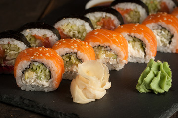 Maki rolls and nigiri sushi on a wooden table. Salmon, avocado and caviar rolls.