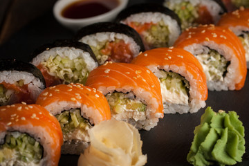 Maki rolls and nigiri sushi on a wooden table. Salmon, avocado and caviar rolls.