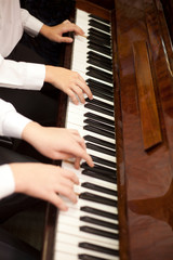 Children play piano in four hands