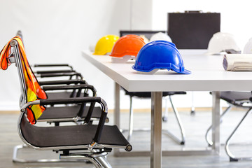 Safety helmet on table in office , engineer concept Teamwork of building construction