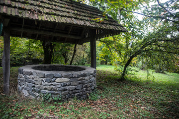 Abandoned well in the forest. Waiting for a terrible girl with a long hair. Halloween concept. Selective focus