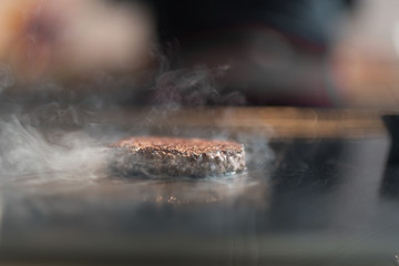 Fresh meat cutlets in a frying pan grill. A lot of steam or smoke