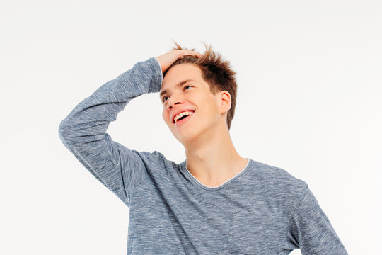 Attractive young man teenager laughing with hand straightens her
