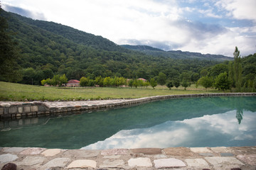 Obraz premium selective focus table near outdoor swimming pool with mountain background