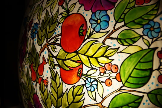 Colorful round hand-painted glass lamp with stained glass paints, with a floral pattern with leaves and flowers