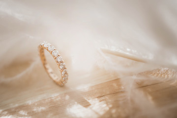 Close up of an elegant diamond ring and feather on pink background. soft and selective focus. Love...