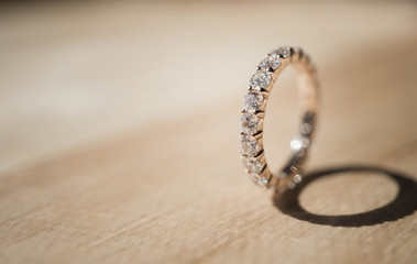 Close up of elegant diamond ring on wooden background. soft and selective focus. Love and wedding...