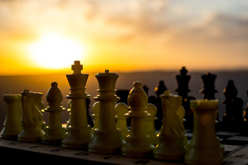 chess board game concept of business ideas and competition and strategy ideas. Chess figures on a chessboard outdoor sunset background.