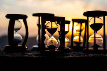 Hourglass Passing of Time Lapse Clouds. An hourglass in front of a bright blue sky with puffy white...