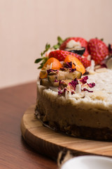 Cake with berries and fruit close-up. White cake on a wooden table.