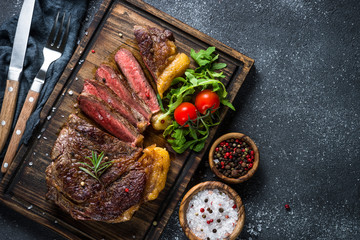Grilled beef steak ribeye on wooden cutting board. 