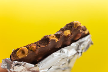 Bite chocolate bar against yellow background