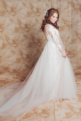 Fototapeta premium Beautiful and romantic bride in wedding dress with long sleeves. Young redheaded woman in wedding dress