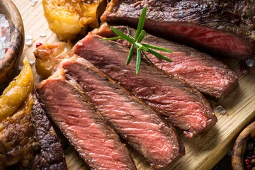 Tuinposter Grilled beef steak ribeye on wooden cutting board.  © nadianb