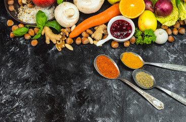 colorful, healthy herbs, spices, fruits and vegetables on black, stone table