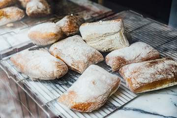Freshly and warm baked bread rolls place on top marble counter for sell. Homemade by artisan.