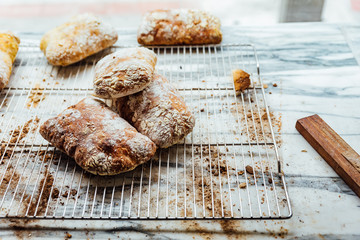 Freshly and warm baked bread rolls place on top marble counter for sell. Homemade by artisan.