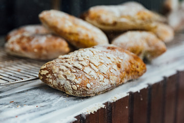 Freshly and warm baked bread rolls place on top marble counter for sell. Homemade by artisan.