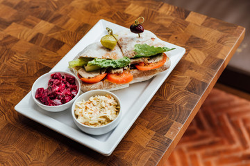 Grilled chicken sandwich made with homemade bread, tomato and lettuce served with beetroot salad and coleslaw.