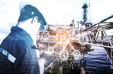 Double exposure of Engineer or Technician man with digital icon operated platform or plant by using tablet with offshore oil and gas platform background for industry business concept