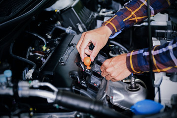 Close up hands checking lube oil level of car engine from deep-stick for service and maintenance...