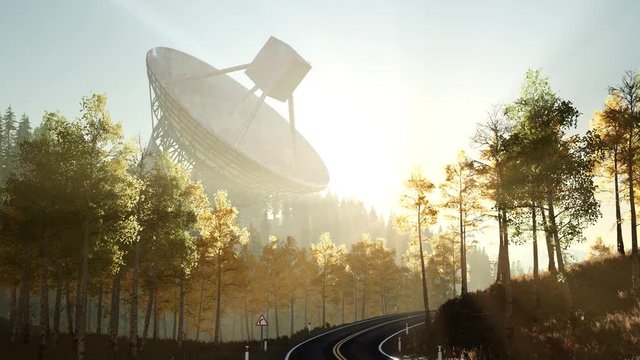 The observatory radio telescope in forest at sunset
