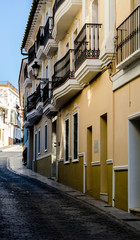 beautiful and picturesque narrow street with white facades of buildings, Spanish architecture