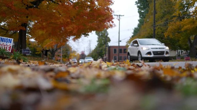 Low Angle Of Traffic Driving Down Street In Pennsylvania Neighborhood On Peaceful Autumn Afternoon