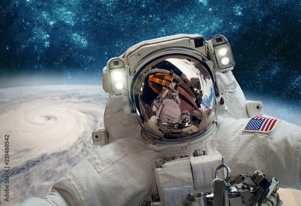 Canvas Prints astronaut in outer space against the backdrop of the planet earth. typhoon over planet earth.