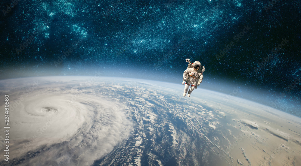 Poster astronaut in outer space against the backdrop of the planet earth. typhoon over planet earth.