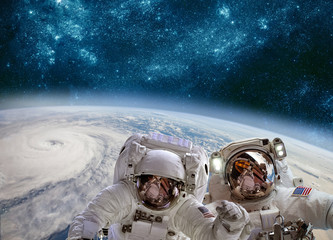 Astronaut in outer space against the backdrop of the planet earth. Typhoon over planet Earth.