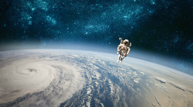 Fototapeta Astronaut in outer space against the backdrop of the planet earth. Typhoon over planet Earth.