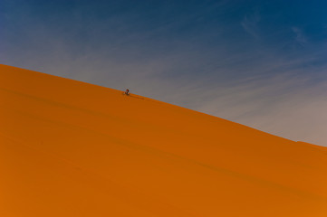 Fototapeta na wymiar Rider on a dune in Erg Chebbi, Merzouga, Morocco